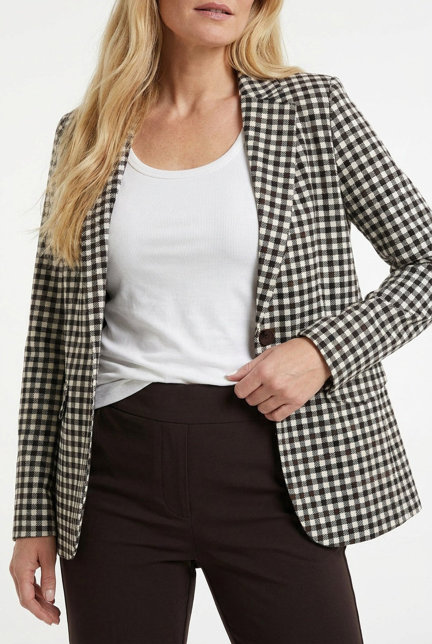 detail geruite blazer op een bruine broek en met wit shirt eronder