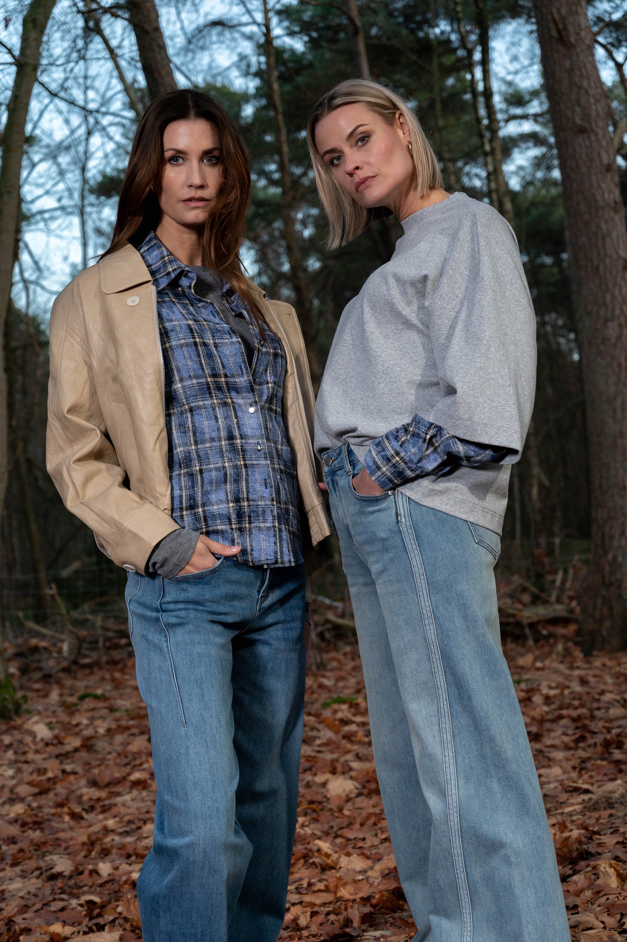 twee dames die de nieuwe herfstcollectie laten zien met een blauw geruit blousje en een grijs oversized t-shirt met diezelfde geruite mouwen verwerkt in het shirt