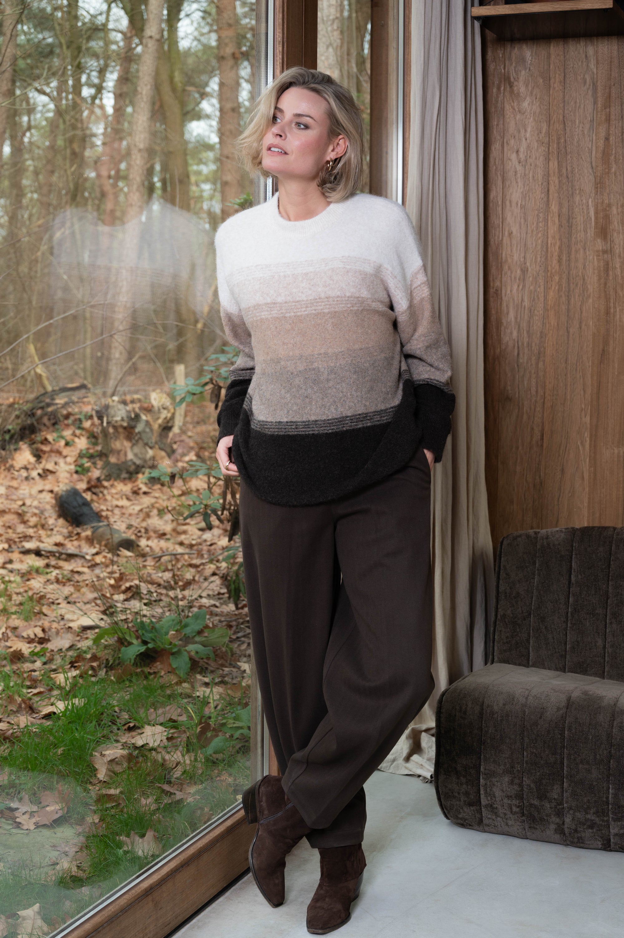 herfstoutfit met een warme damestrui met kleurverloop op een bruine broek met bruine laarsjes eronder