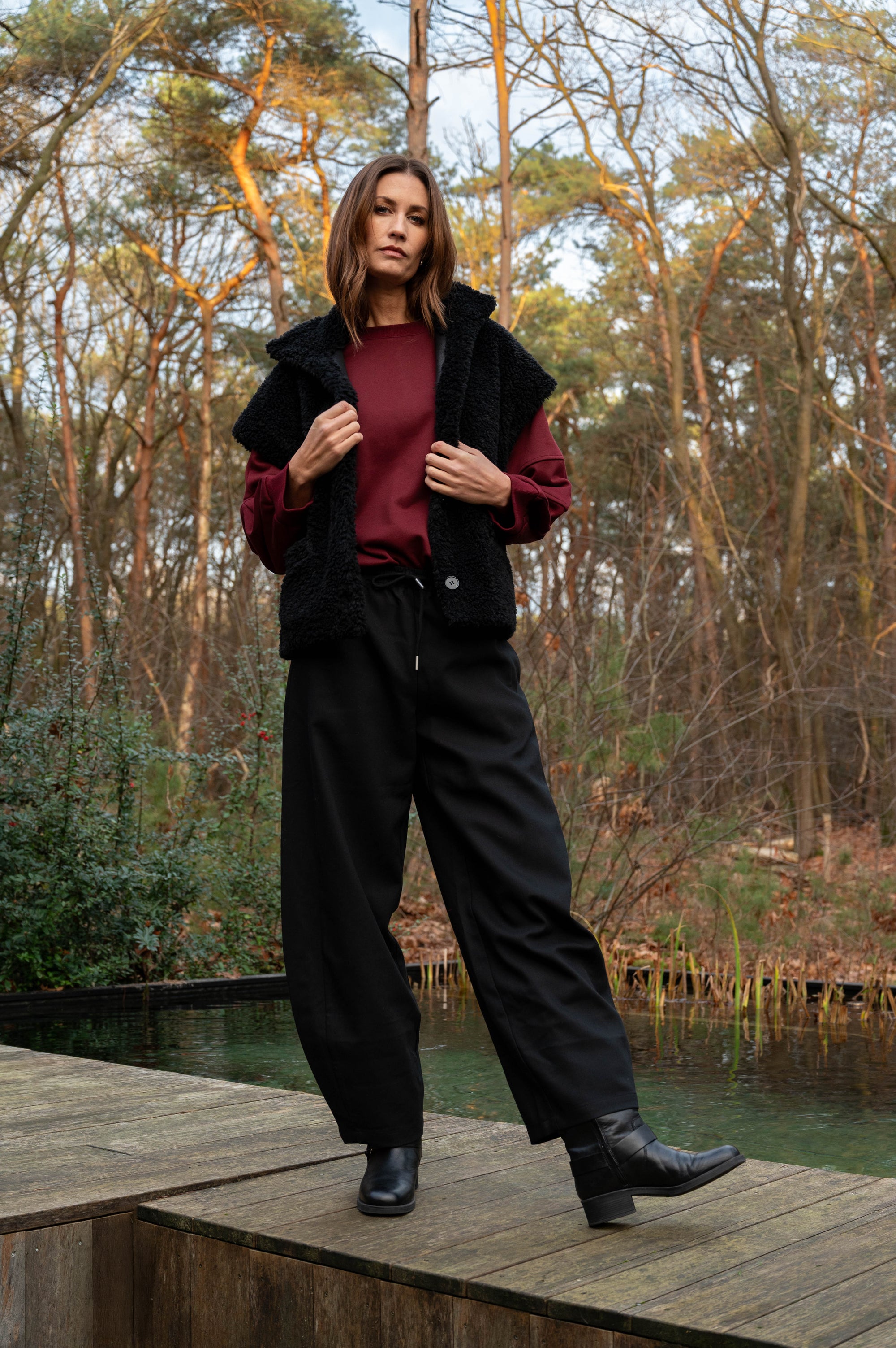 combineer de zwarte pantalon barrel broek vadou met een rode oversized trui en een zwart zacht jasje met korte mouwen