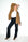 model draagt de bowie blue mocca flared fit damesjeans van dnm pure gecombineerd met een witte top en langere herfstjas
