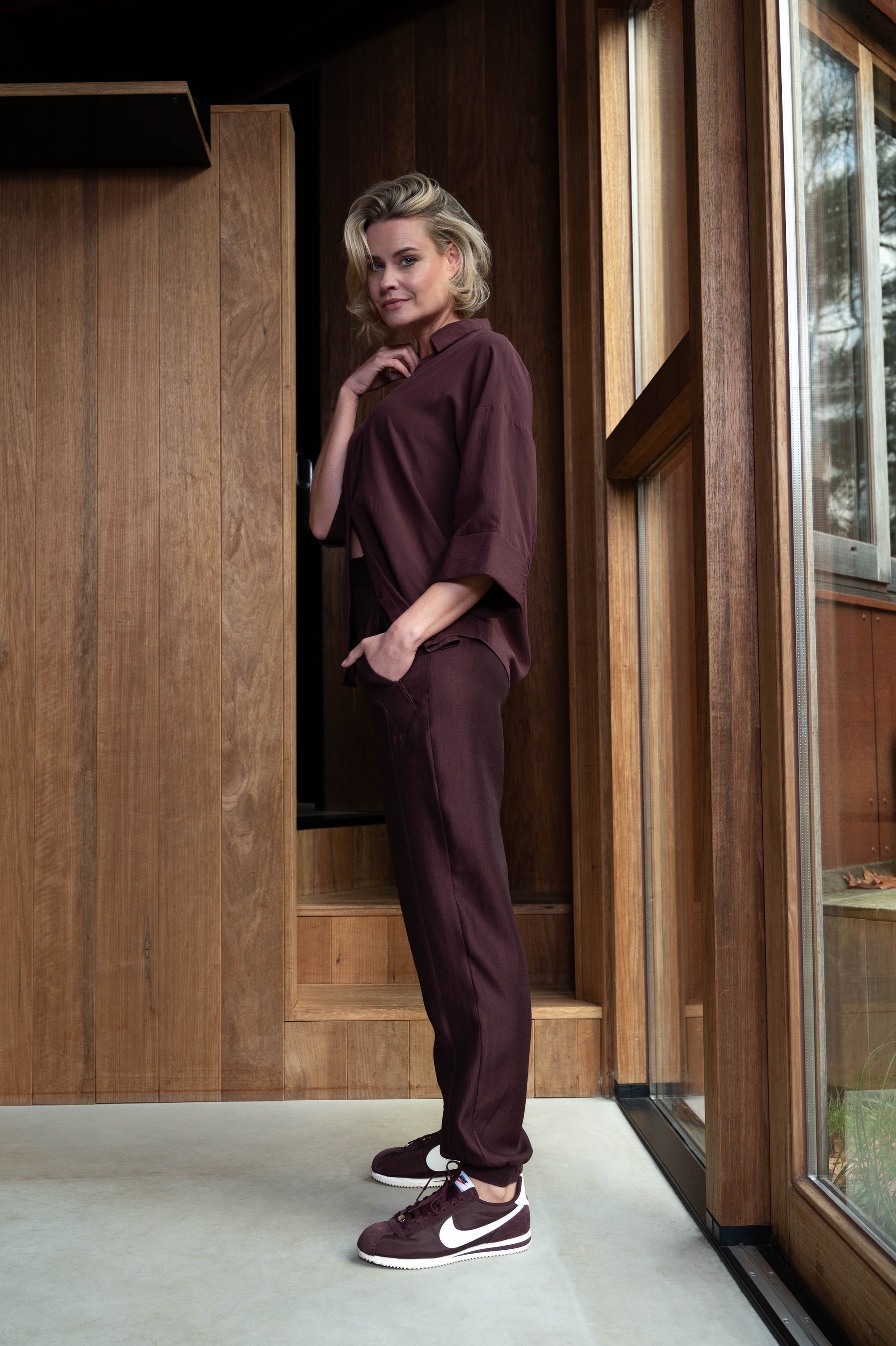 zijaanzicht van passende herfst outfit in wijnrood met broek en bijpassende blouse