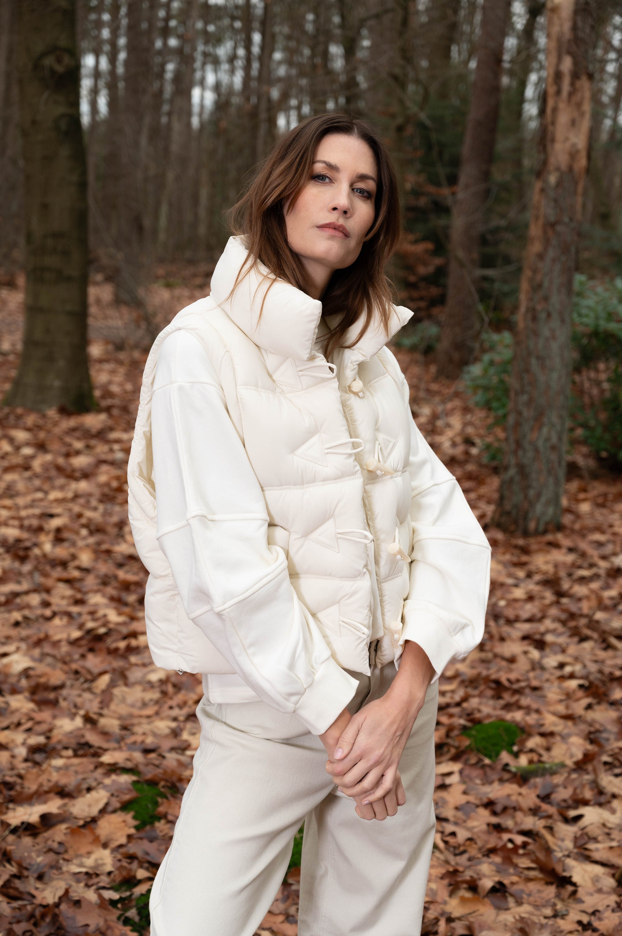 model draagt de off-white trui verlita in combinatie met een off-white bodywarmer en broek