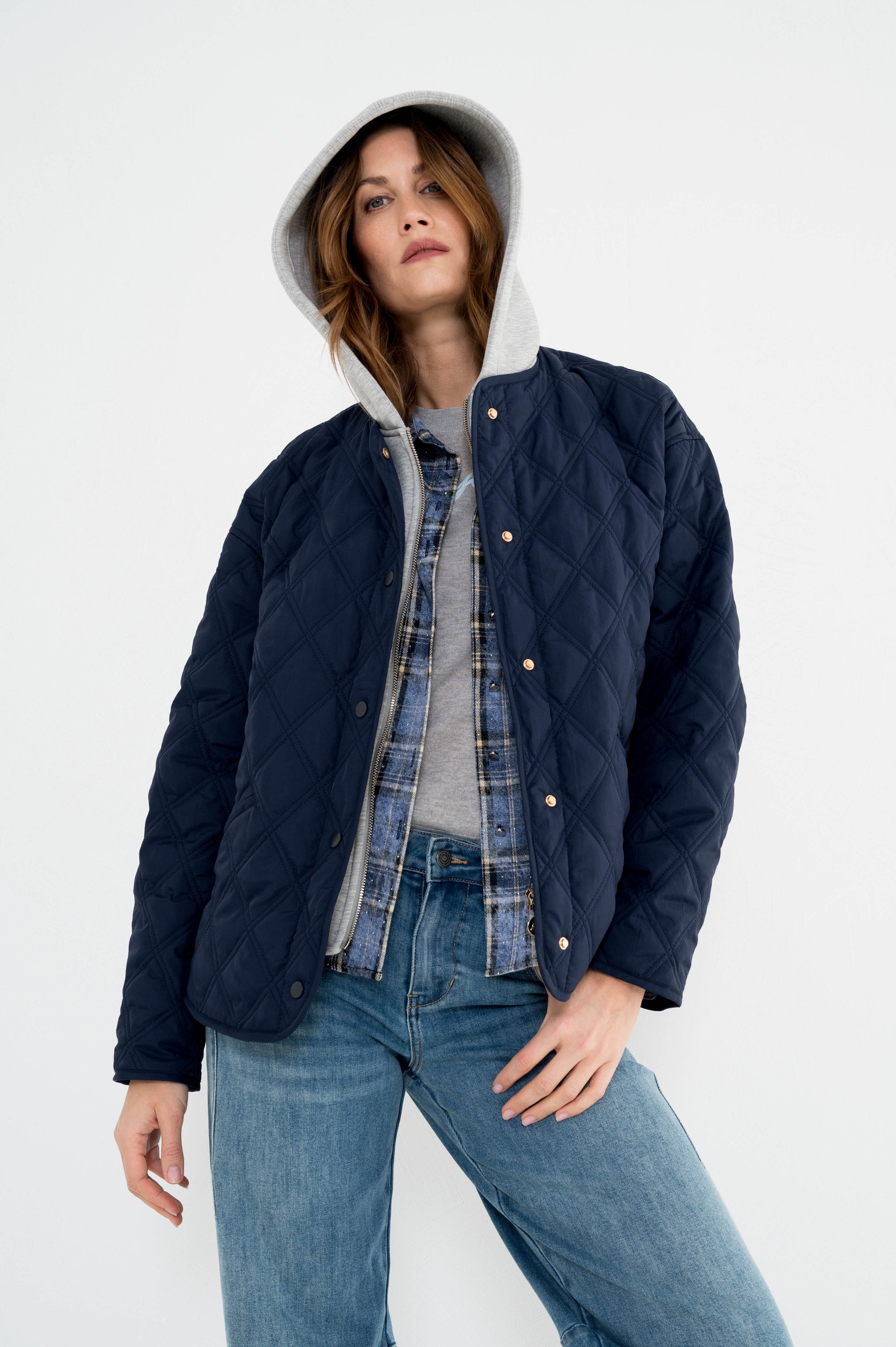 model draagt de vorges donkerblauw dames jasje van maicazz met lange mouwen in gewatteerd ruitpatroon