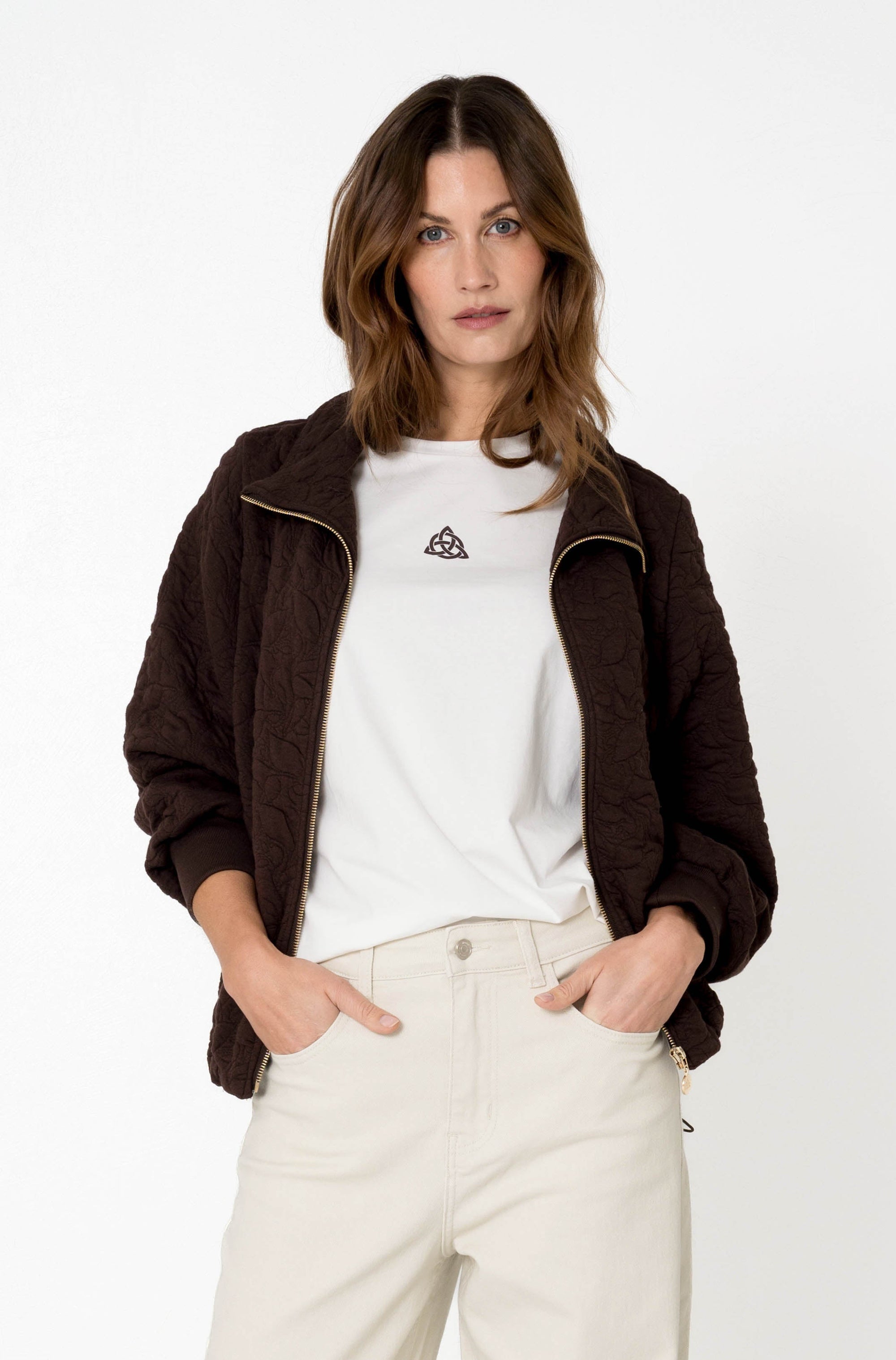 model draagt een donkerbruin jasje met ritssluiting met een maicazz basic shirt en off-white broek