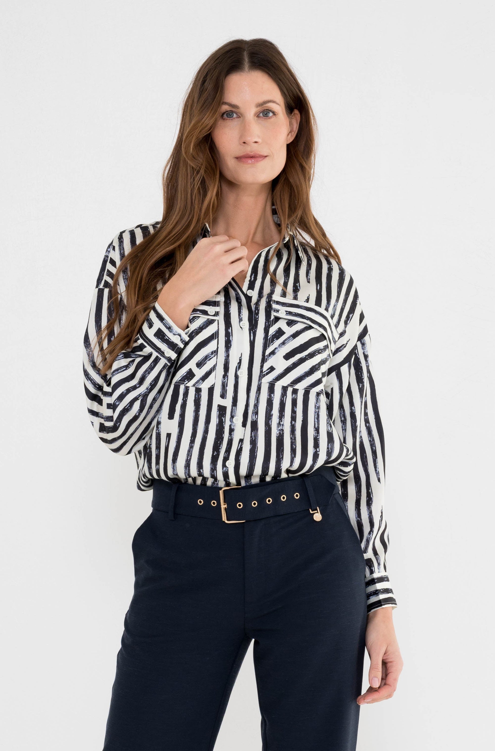 dame draagt een blauw gestreepte blouse op een blauwe broek