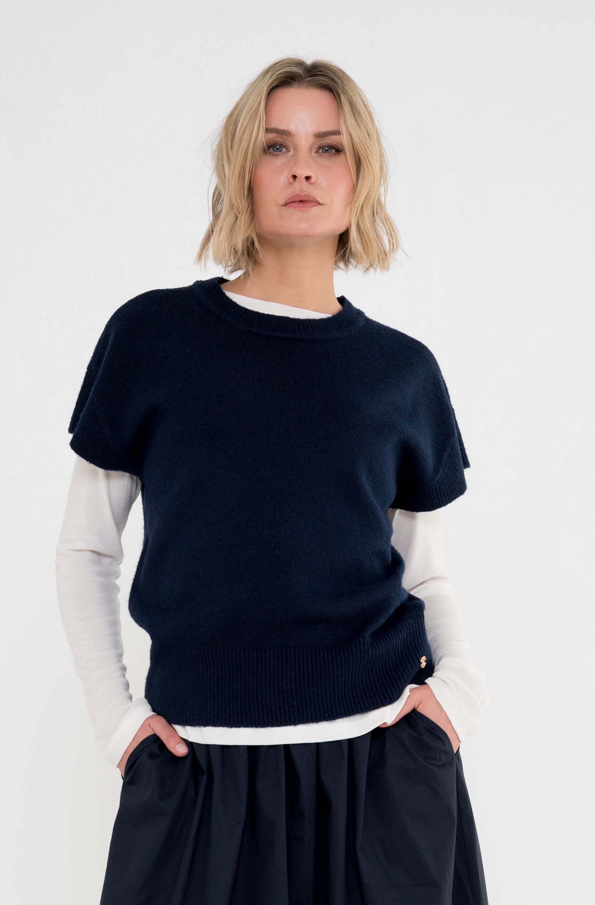 model draagt het donkerblauw shirt vita met korte mouwen over een wit shirt met lange mouwen