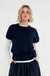 model draagt het donkerblauw shirt vita met korte mouwen over een wit shirt met lange mouwen