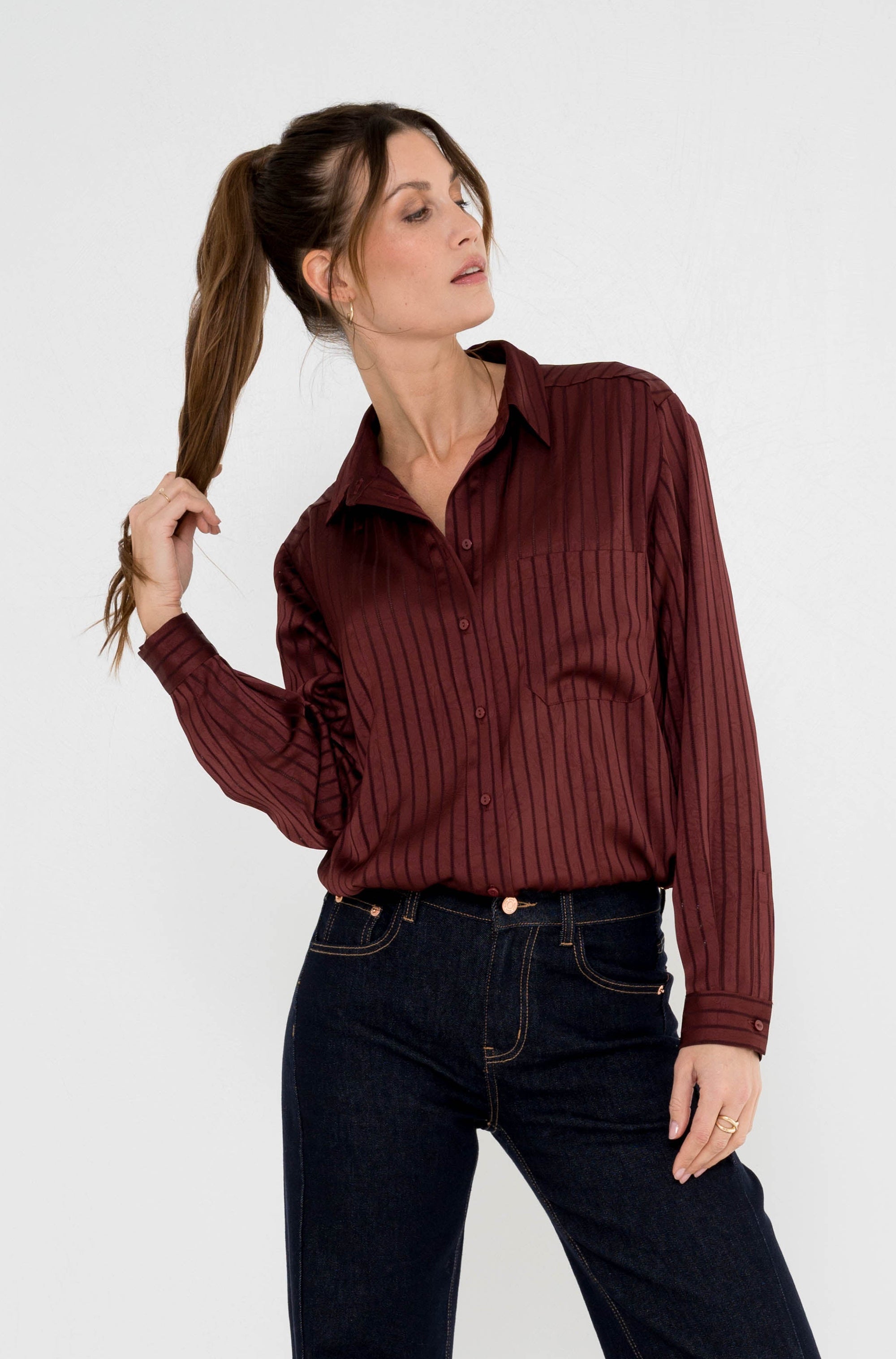 vammy wijnrode blouse met streepdesign, borstzak en knoopsluiting op een donkere spijkerbroek