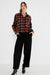 model draagt zwarte wide fit barrel met een geblokte herfstblouse