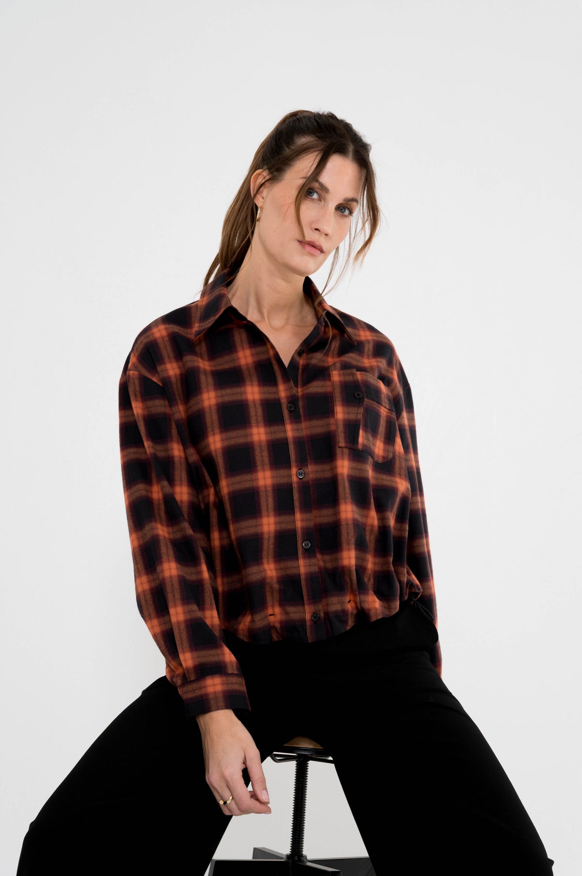complete damesoutfit met geruite herfstblouse op een zwarte broek