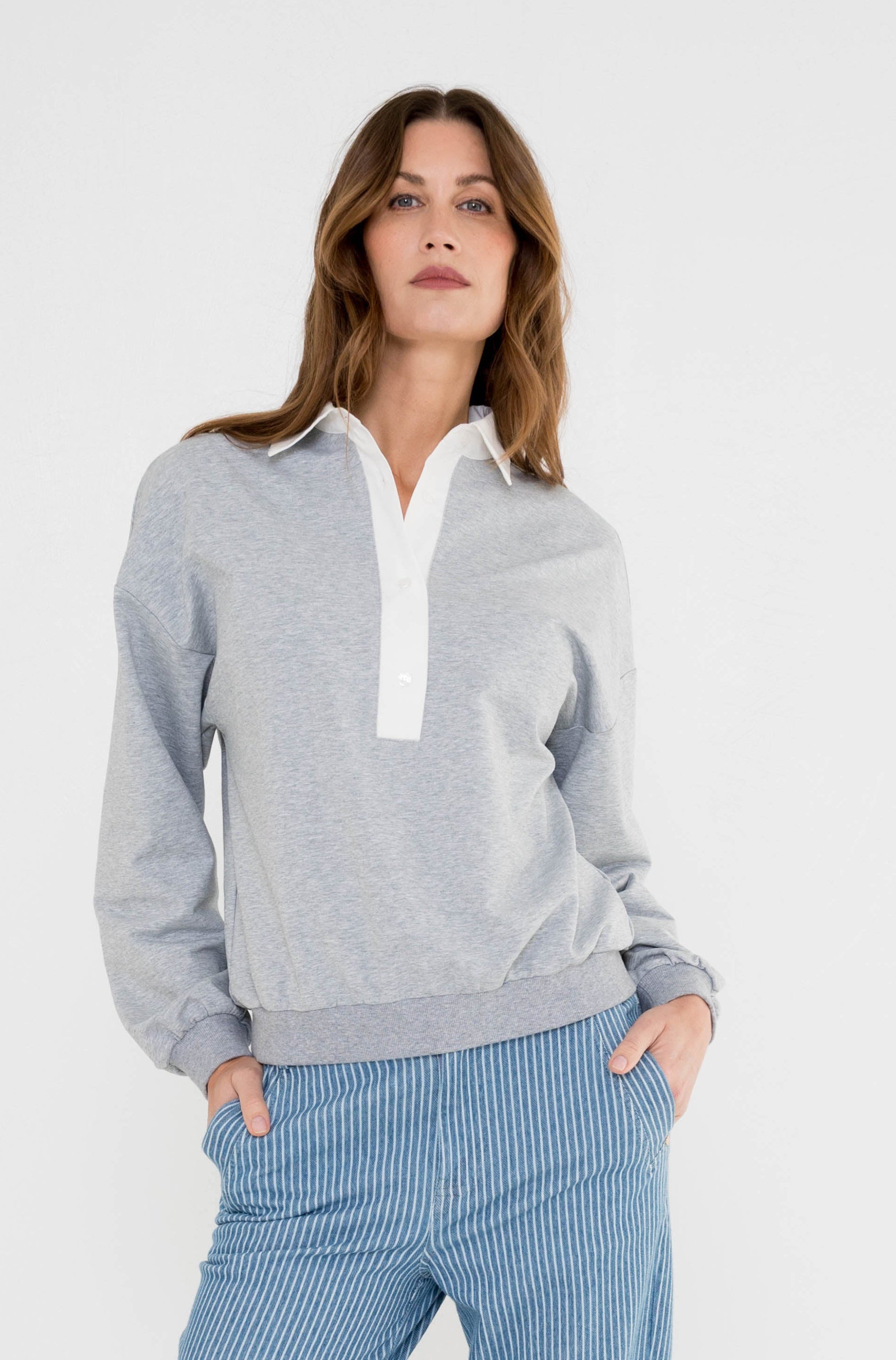 grijze sweater met poplin kraag zorgt voor een sportieve look op de blauw gestreepte jeans 