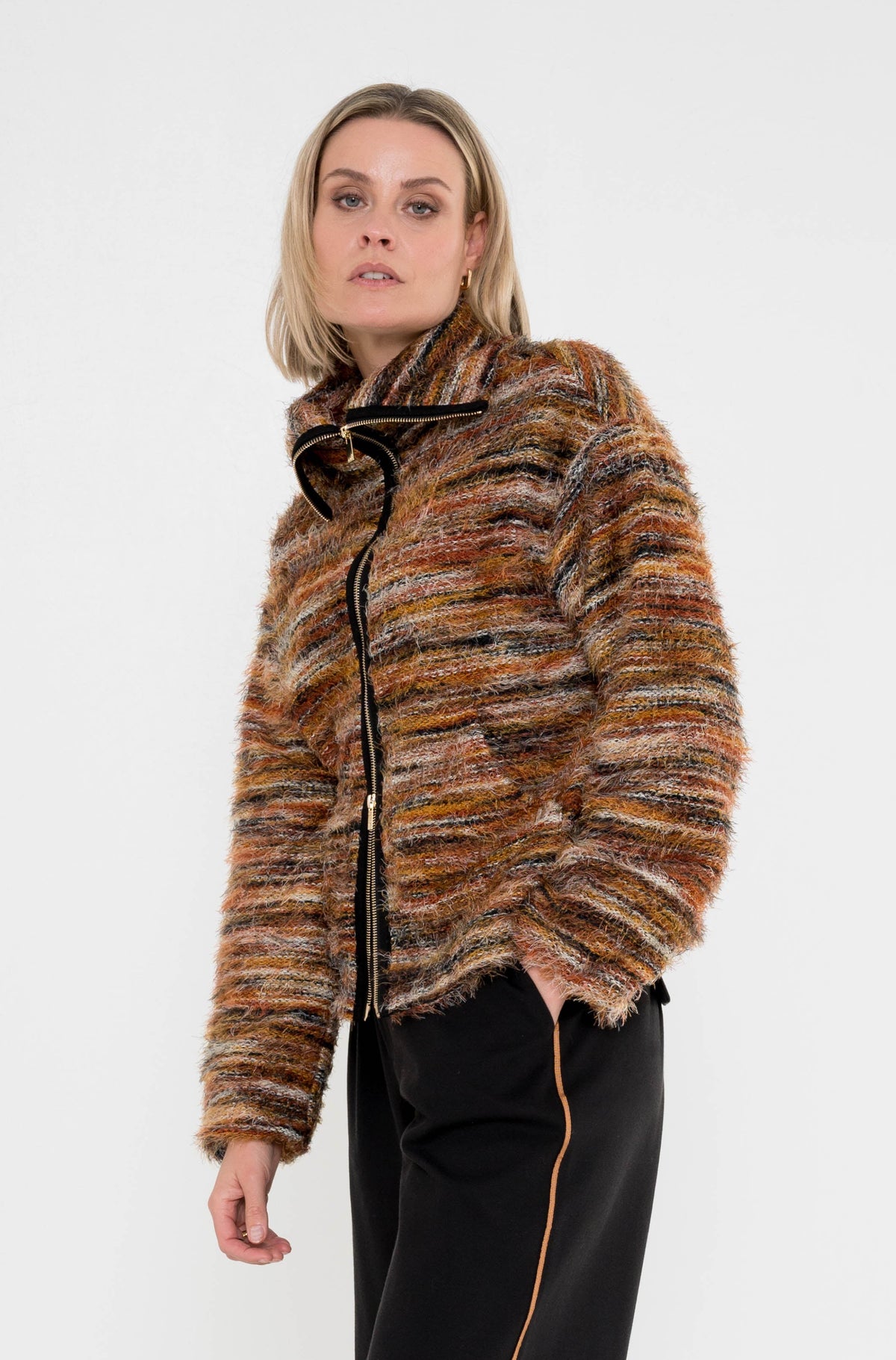 model draagt rumour vest in herfsttinten op een zwarte broek met cognac streep aan de zijkant