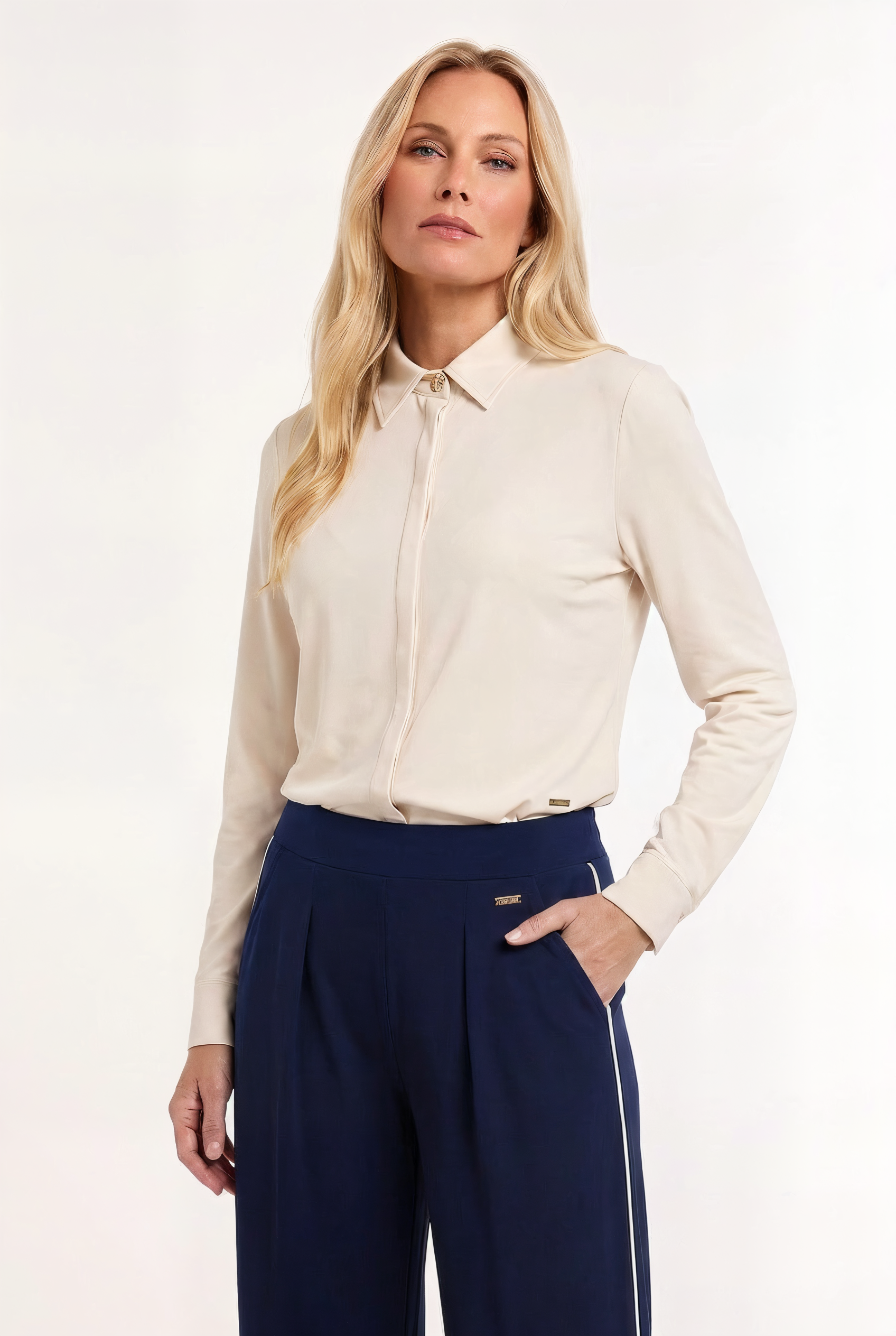 model draagt een offwhite travel blouse op een donkerblauwe travel broek 