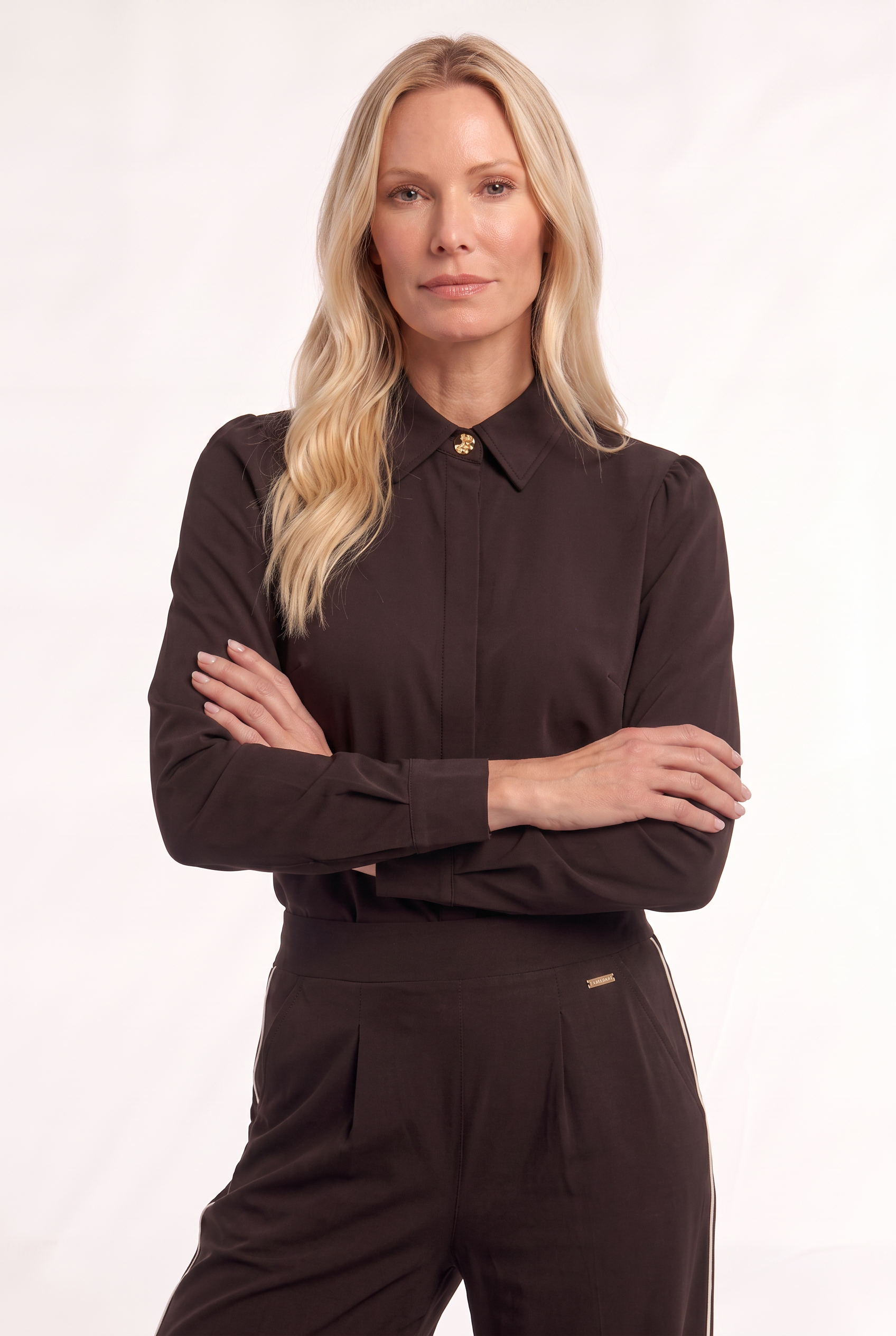 dame draagt herfsttrend bruin als complete outfit met deze travelblouse en travelbroek
