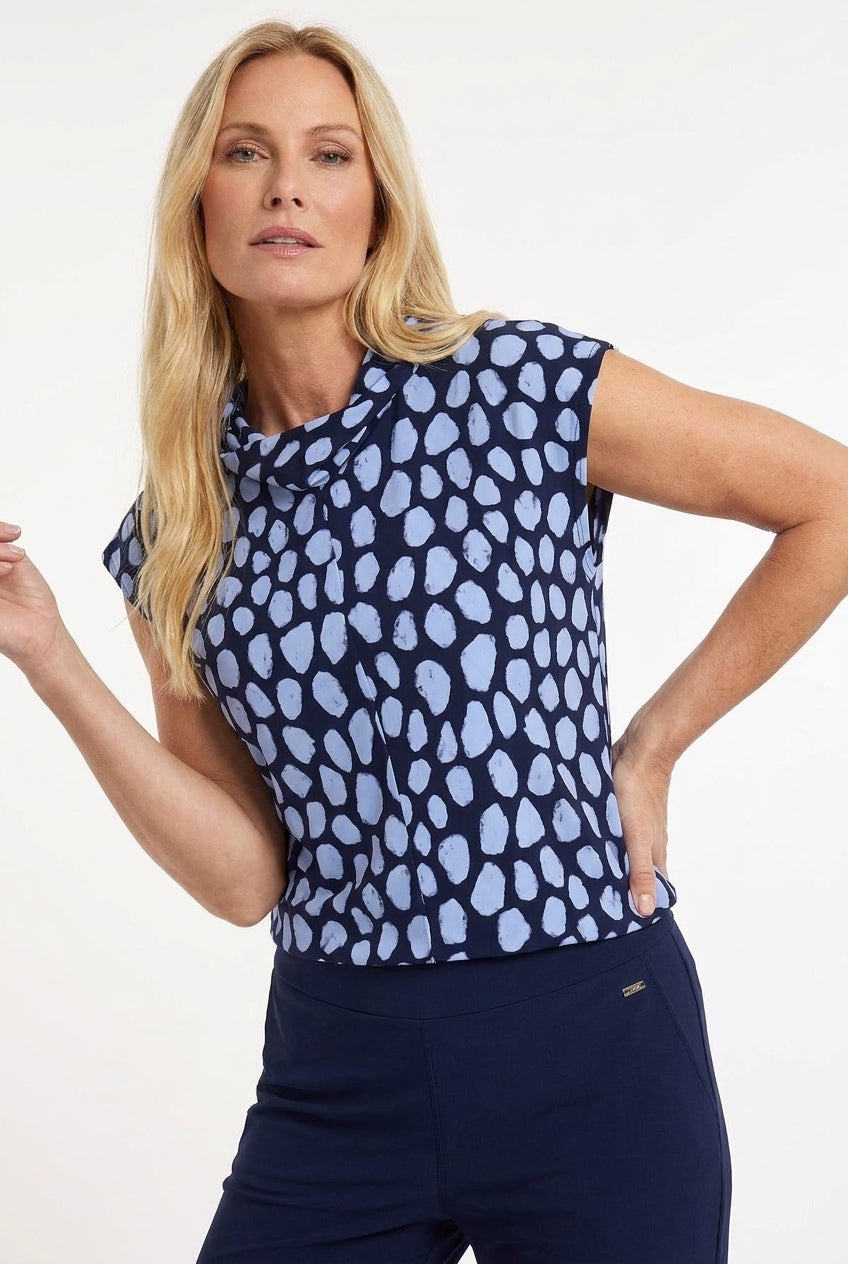 blauw gestipte t-shirt met sjaalkraag op een donkerblauwe travel broek