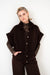 outfit met trendkleur bruin met een warm gebreid vest met een kanten shirt op een broek