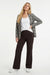 model draagt bruine flared fit travelbroek met daarboven een wit shirt en bruin zwart wit geruite blazer